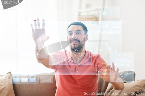 Image of happy man touching virtual screen at home