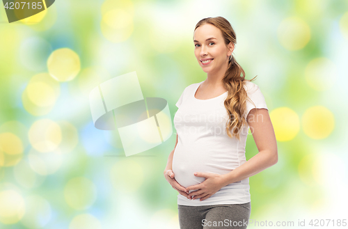 Image of happy pregnant woman touching her big belly