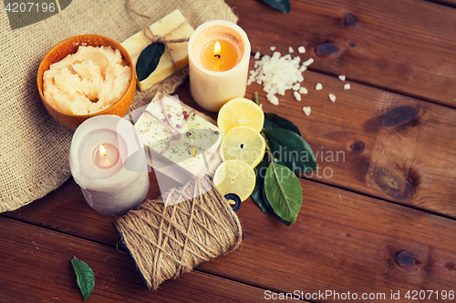 Image of close up of natural soap and candles on wood