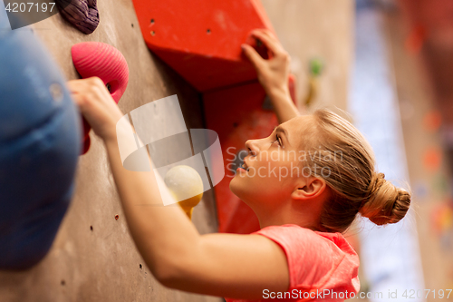 Image of young woman exercising at indoor climbing gym