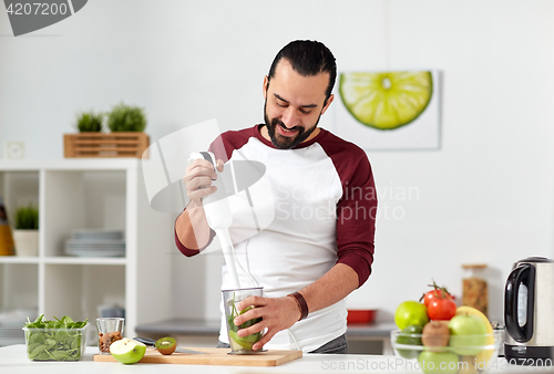 Image of man with blender cooking food at home kitchen