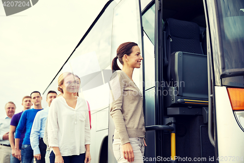 Image of group of happy passengers boarding travel bus