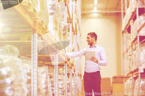 Image of happy businessman with tablet pc at warehouse