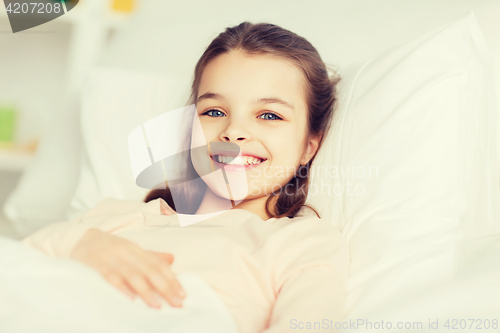 Image of happy smiling girl lying awake in bed at home