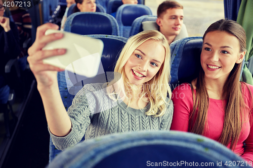 Image of women taking selfie by smartphone in travel bus