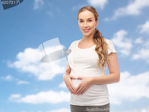 Image of happy pregnant woman showing heart gesture