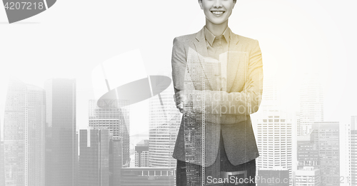 Image of smiling businesswoman over city buildings