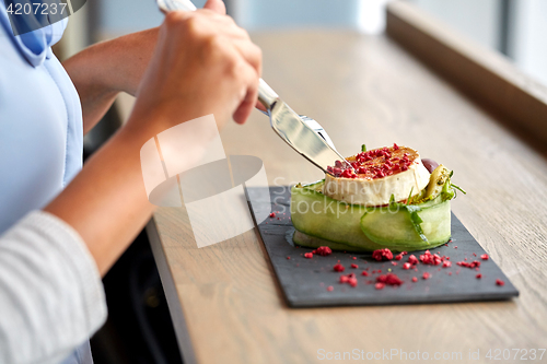 Image of woman eating goat cheese salad at restaurant