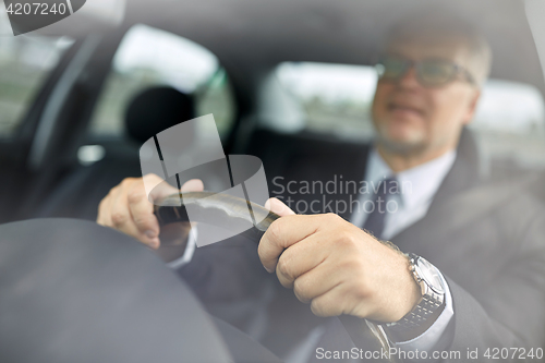 Image of senior businessman hands driving car
