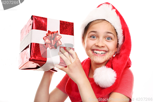 Image of Christmas dreams, magical Christmas time Happy child in the cap of St. Nicholas of packaged gift 