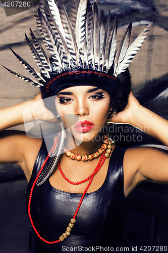 Image of young pretty woman with make up like red indian, futher in hair,