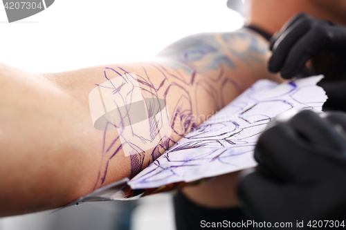 Image of Creating a tattoo in a tattoo parlor.