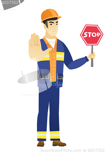 Image of Asian builder holding stop road sign.