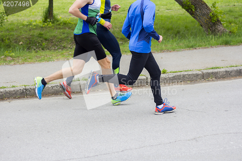 Image of Marathon running race three runners on city road