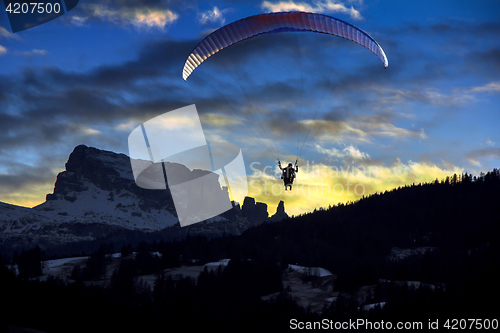 Image of Paraglider flies in the blue winter sky