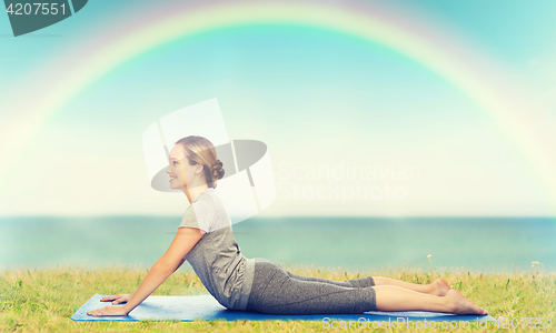 Image of woman making yoga in dog pose on mat