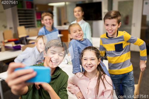 Image of group of school kids taking selfie with smartphone