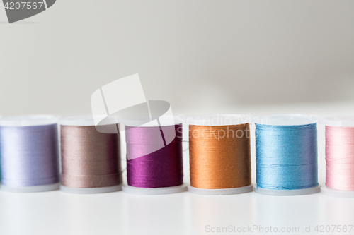 Image of row of colorful thread spools on table