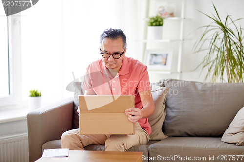 Image of man opening parcel box at home