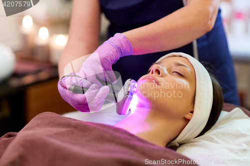 Image of young woman having face microdermabrasion at spa