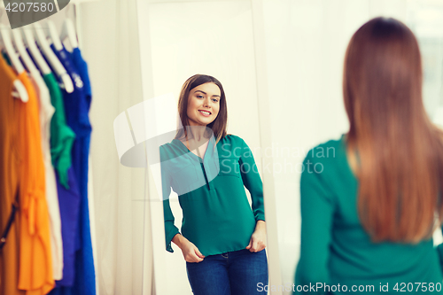 Image of happy woman posing at mirror in home wardrobe