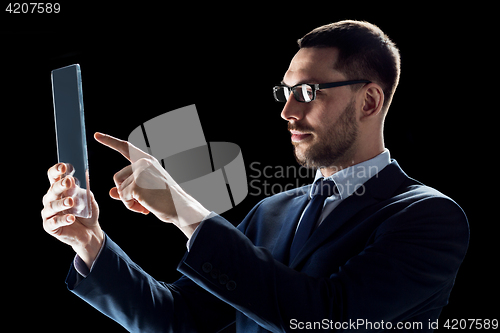 Image of businessman in suit with transparent tablet pc