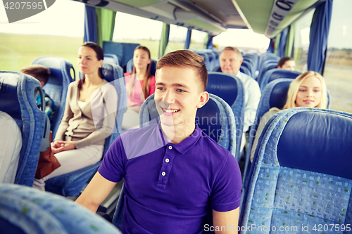 Image of happy young man sitting in travel bus or train