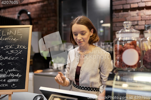 Image of happy woman or barmaid with cashbox at cafe