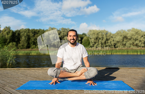 Image of man making yoga in scale pose outdoors