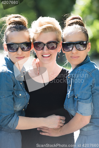 Image of portrait of three young beautiful woman with sunglasses