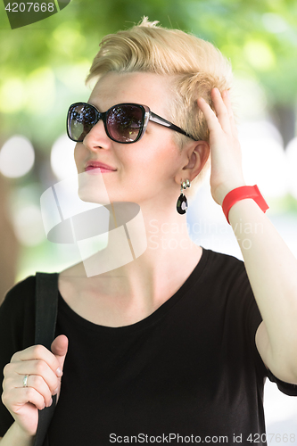 Image of young woman with short blond hair and sunglasses