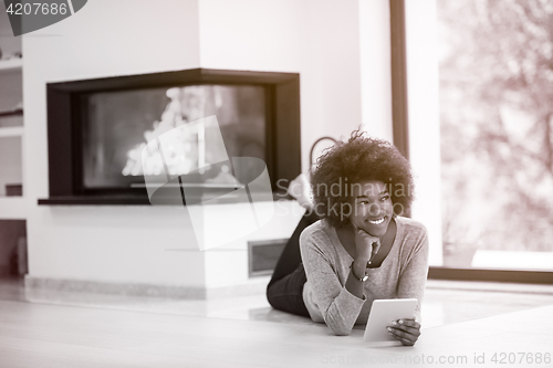 Image of black women used tablet computer on the floor