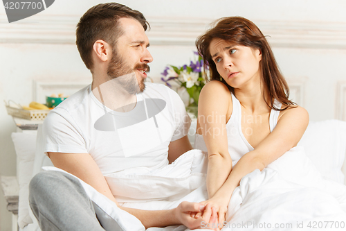 Image of Young adult heterosexual couple lying on bed in bedroom