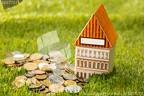 Image of Plant growing in Coins glass jar for money on green grass