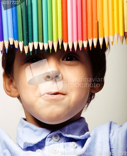Image of little cute boy with color pencils close up smiling, education face colored