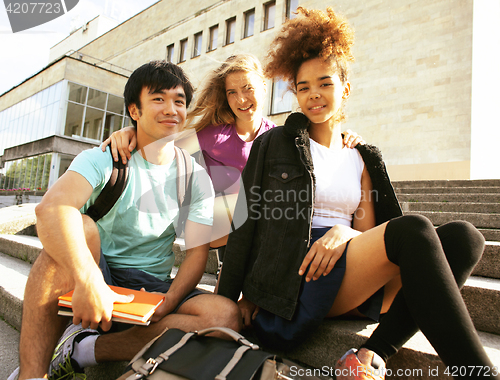 Image of cute group of teenages at the building of university with books 