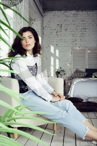 Image of young pretty woman in her bedroom sitting in chair, lifestyle people concept