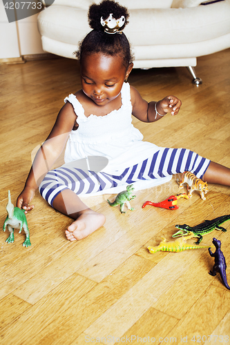 Image of little cute african american girl playing with animal toys at ho