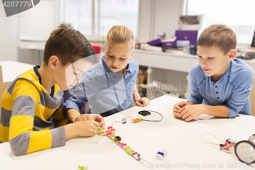 Image of happy children building robots at robotics school