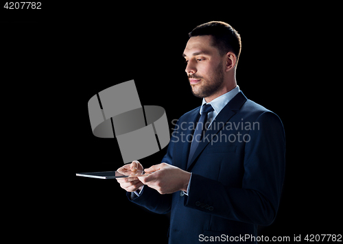Image of businessman in suit with transparent tablet pc