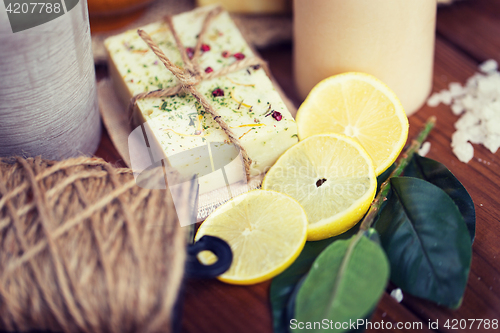 Image of close up of natural soap and candles on wood