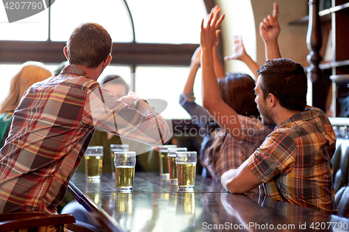 Image of football fans or friends with beer at sport bar