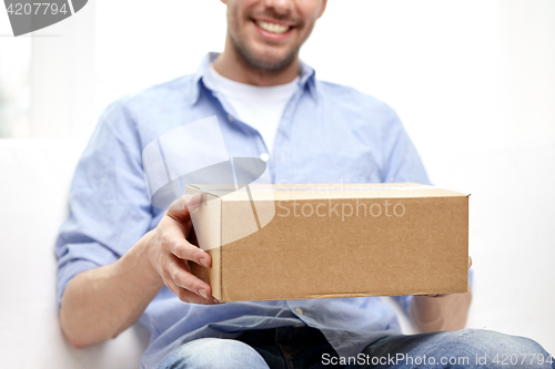 Image of happy man with cardboard box or parcels at home