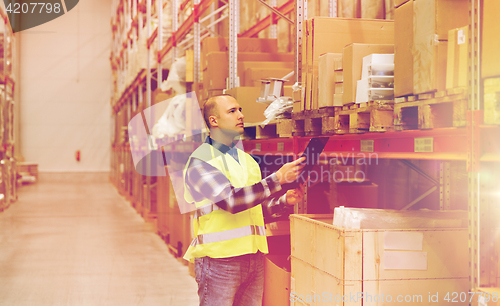 Image of man with clipboard in safety vest at warehouse