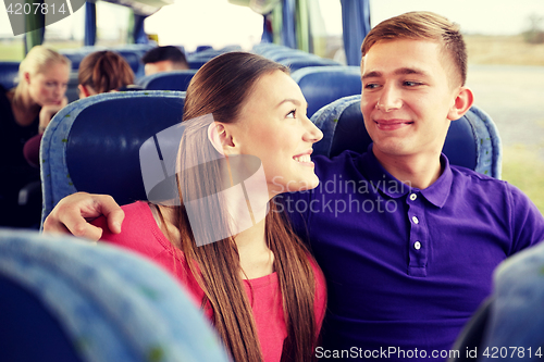 Image of happy teenage couple or passengers in travel bus