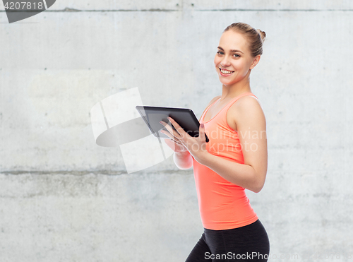 Image of happy smiling sportive young woman with tablet pc