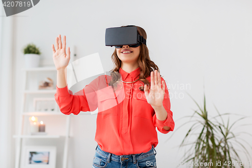 Image of happy woman in virtual reality headset at home