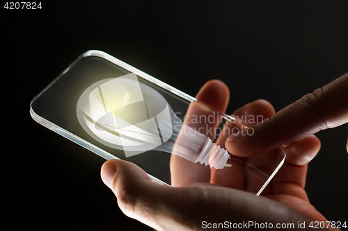 Image of close up of hands with lightbulb smartphone