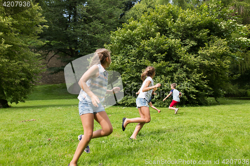 Image of group of happy kids or friends playing outdoors