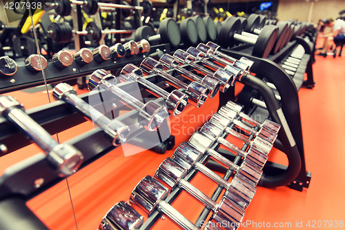 Image of close up of dumbbells and sports equipment in gym